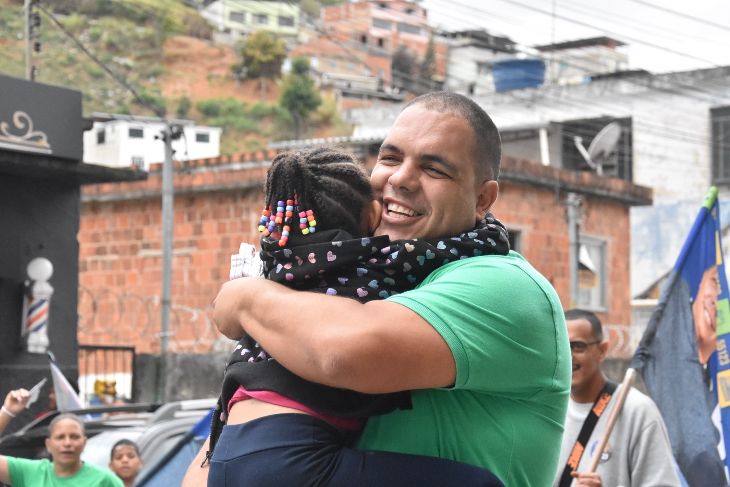 Tiago Bonecão abraçando uma criança em um bairro de Juiz de Fora